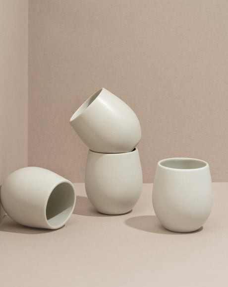 Set of white ceramic cups on a beige background