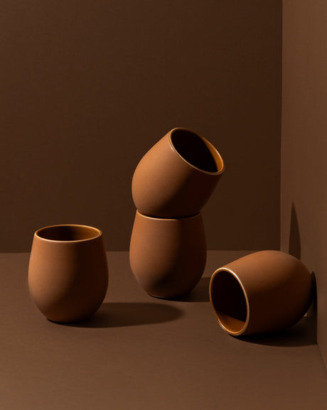 Set of brown ceramic cups on a brown background