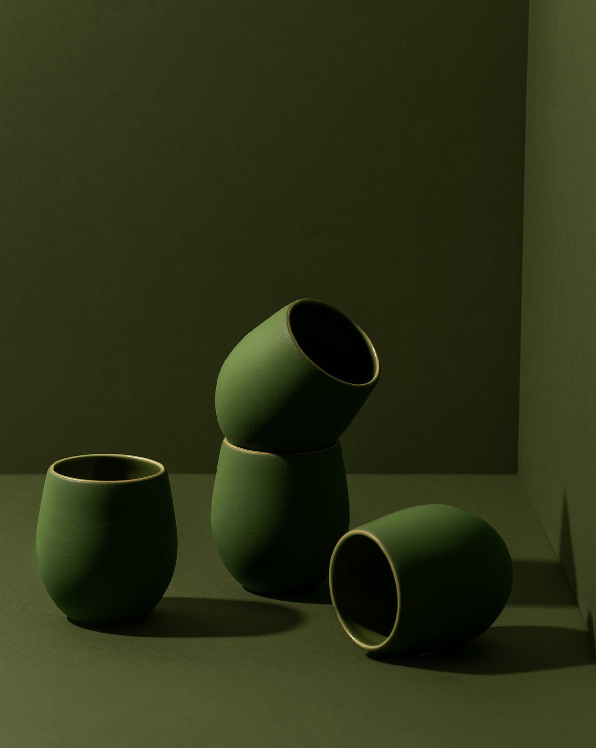 Set of green ceramic cups on a dark background