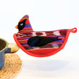 Colorful bird-shaped potholder on a white background