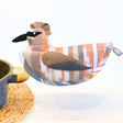 Decorative bird-shaped pot holder with a striped pattern on a white background