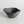 Black ceramic bowl with handle on a white background