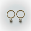 Gold hoop earrings with pearls on a light gray background