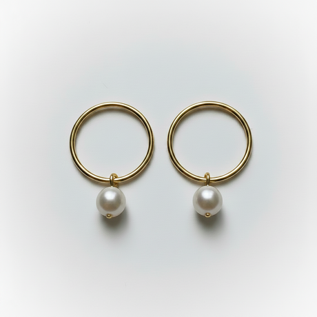 Gold hoop earrings with pearls on a light gray background