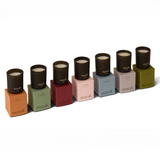 Row of candles in black containers on colorful boxes with 'marak' branding. Collection Votive Set | 3.4oz Soy Wax Scented Candles