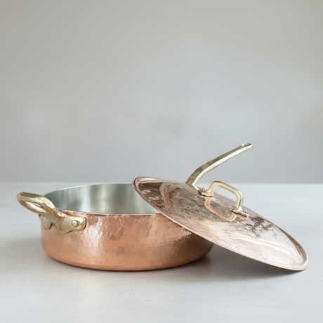 Copper frying pan with lid on a white background
