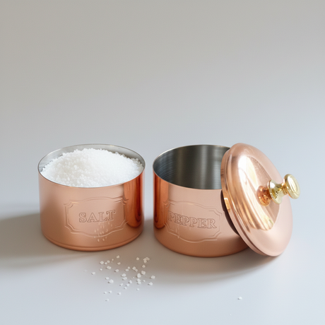Copper salt and pepper cellars on a light background