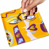 Hand holding a colorful pouch with abstract design on a white background