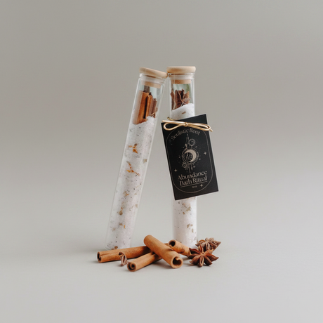 Two glass tubes with cinnamon sticks and star anise on a gray background