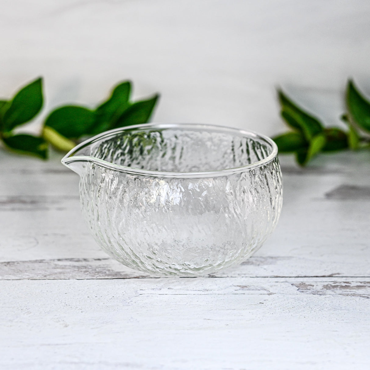 Textured Spouted Glass Matcha Bowl Pattern 2 with bamboo matcha whisk and whisk holder set—a stylish set featured on a light surface with green leaves in the background, perfect for elevating your matcha experience.