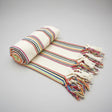 Rolled-up striped towel with colorful stripes on a white background