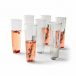 Set of six tall glasses with pink beverages and garnishes on a white background