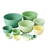 Set of green and yellow bowls and measuring cups on a light surface