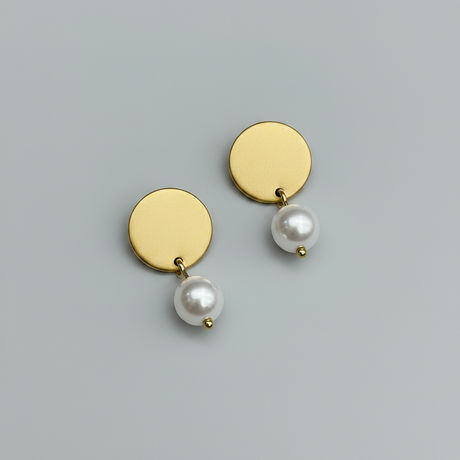 Gold earrings with pearls on a light gray background