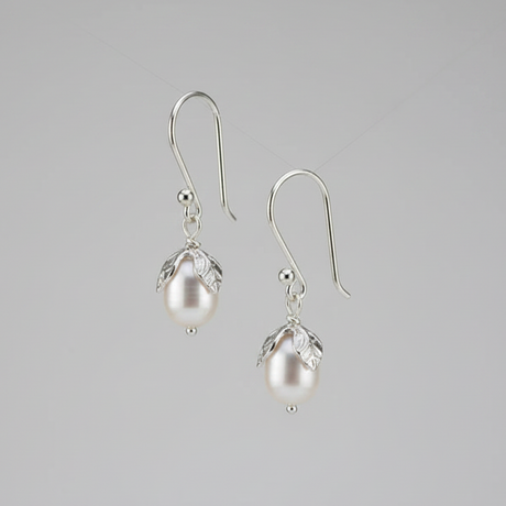 Pair of pearl earrings on a gray background