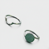 Three rings with different colored stones on a white background