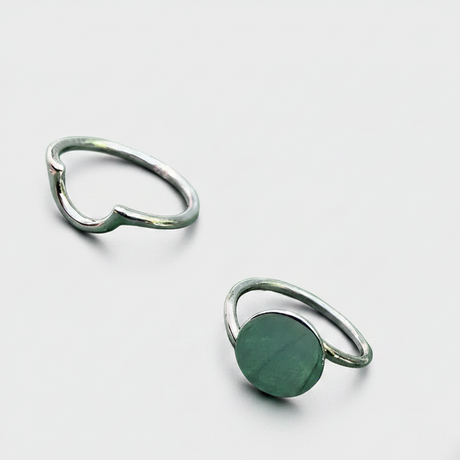 Three rings with different colored stones on a white background
