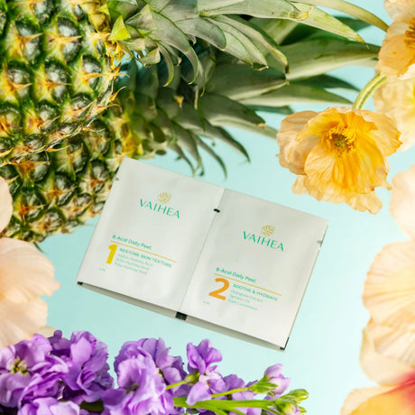 Vaihea skincare product packaging with a pineapple and flowers on a light blue background
