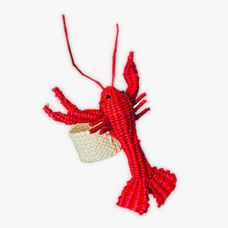 Red lobster-shaped napkin ring with a small woven basket on a white background