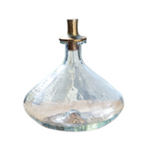 Clear glass decanter with a metallic top on a white background