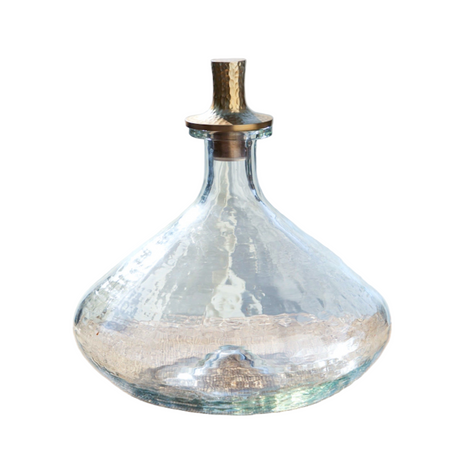Clear glass decanter with a metallic top on a white background