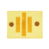 Yellow fabric placemat with brown circular patterns on a white background