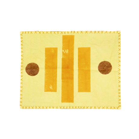 Yellow fabric placemat with brown circular patterns on a white background