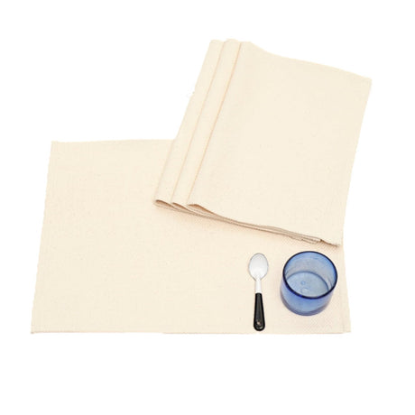 Beige placemats with a spoon and blue glass on a white background