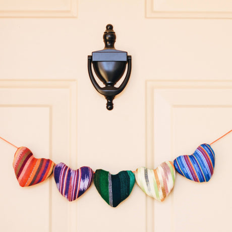Colorful heart-shaped decorations hanging on a door handle.