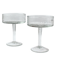 Two clear glass coupe glasses on a white background
