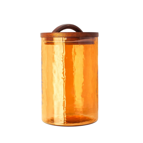 Orange glass jar with a wooden lid on a white background