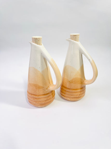 Two ceramic pitchers with a gradient design on a white background