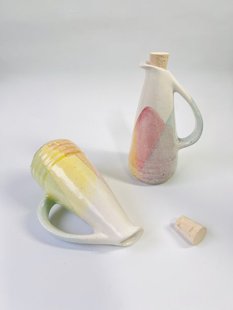 Two ceramic pitchers with abstract designs on a light gray background
