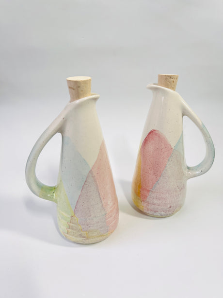 Two ceramic pitchers with abstract designs on a white background