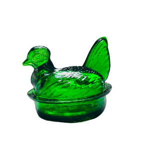 A hand-blown emerald green glass nesting hen with a lid, on a white background.