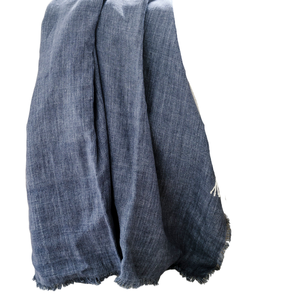 Blue textured blanket draped over a white stool in a home setting