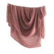 Rose blanket draped over a white background