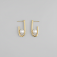 Gold hoop earrings with pearls on a gray background