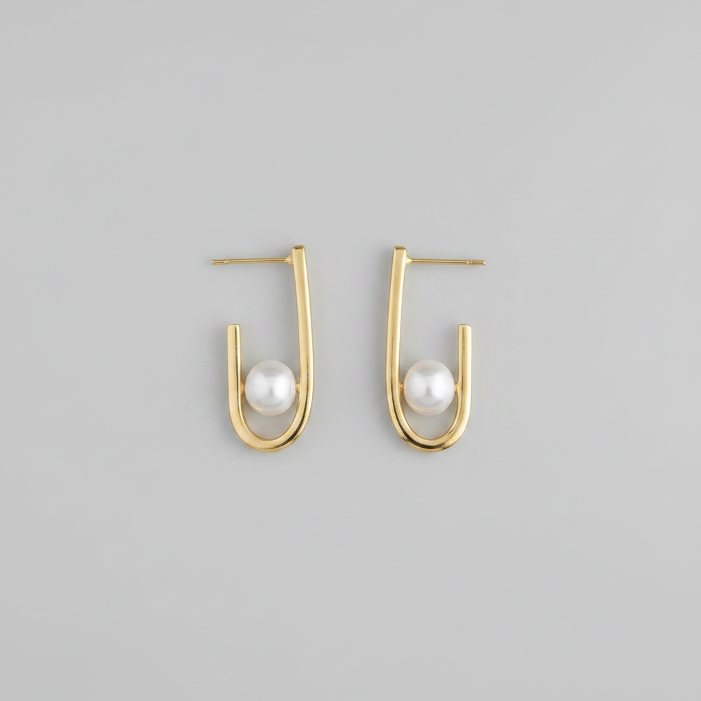 Gold hoop earrings with pearls on a gray background