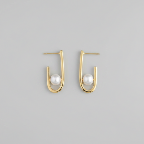 Gold hoop earrings with pearls on a gray background