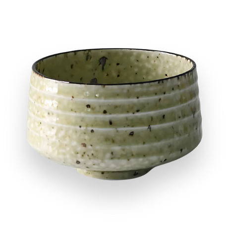 The Kaneni White Ceramic Matcha Bowl showcases a speckled design with horizontal grooves, embodying the essence of Japanese pottery against a bold black background.