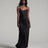 Woman wearing a black slip dress against a gray background