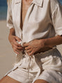 Person wearing a light-colored outfit on a beach