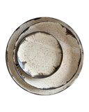 Speckled ceramic plate on a white background
