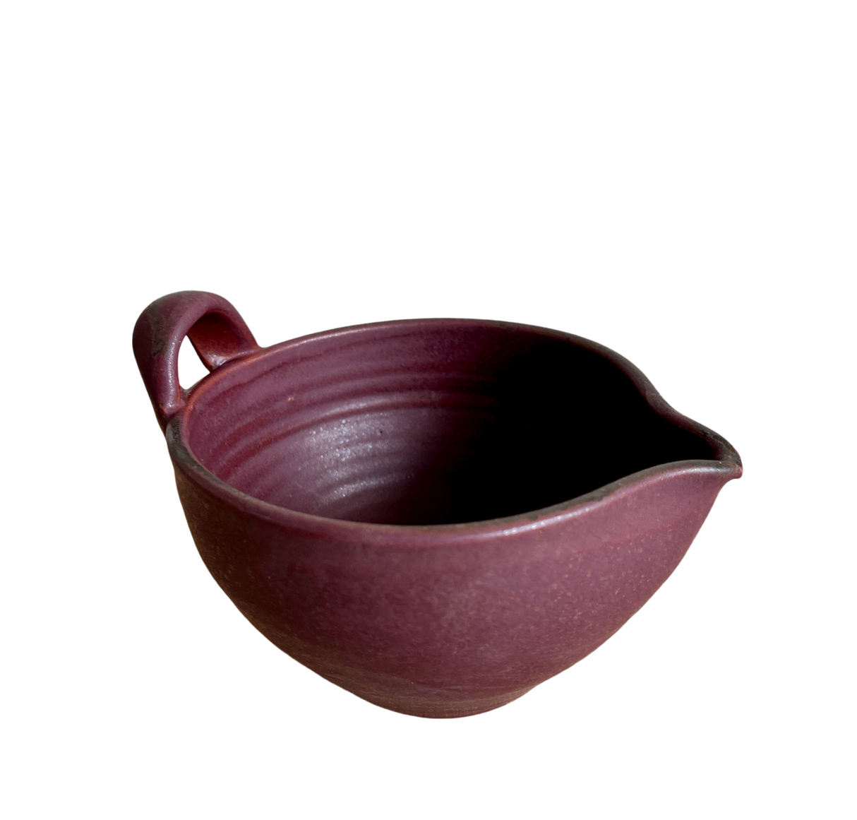 Purple ceramic bowl with a handle on a white background
