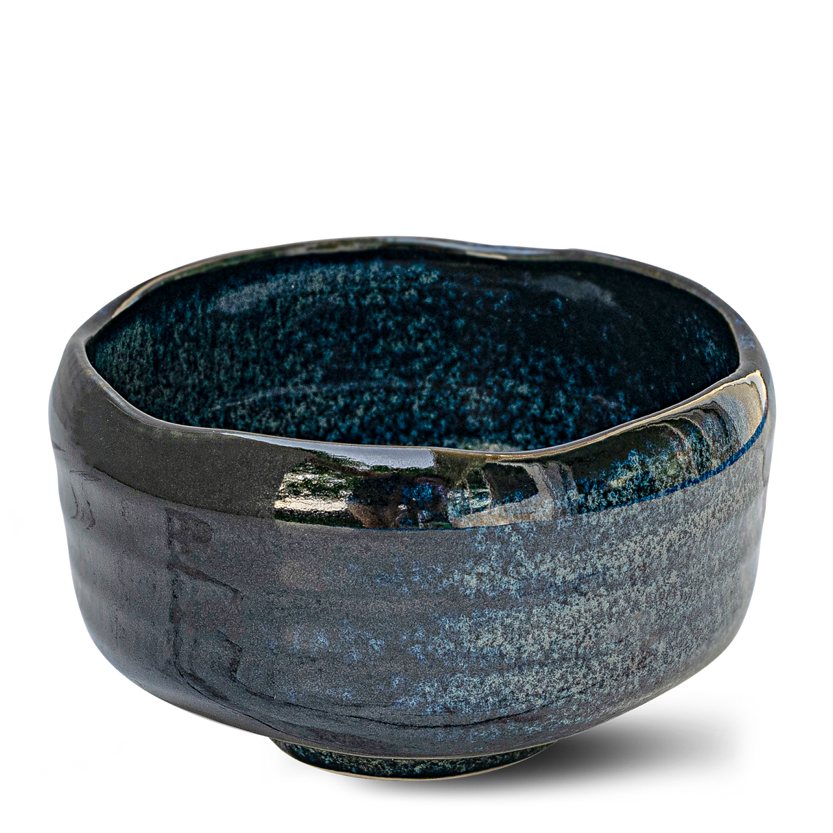 The Indigo Glaze Matcha Bowl, handcrafted in Japan, features a beautifully glossy, textured surface with an irregular rim. Its dark ceramic design enhances its appeal as a refined matcha tea accessory.
