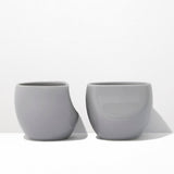 Two gray ceramic cups on a white background