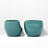 Two teal ceramic cups on a white background