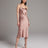 Woman wearing a pink satin slip dress against a plain background