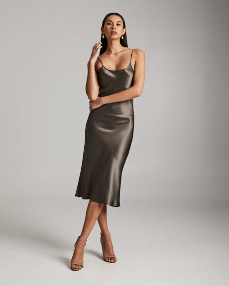 Woman wearing a metallic slip dress against a plain background